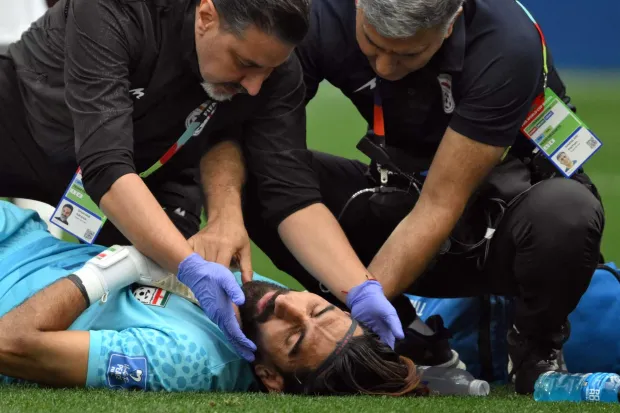 Iran's goalkeeper #01 Alireza Beiranvand receives medical attention during the 2026 World Cup Group G football match between Belgium and Iran at the Los Angeles Stadium in Inglewood on June 21, 2026. (Photo by Patrick T. Fallon/AFP)