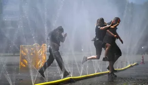 Employees of the public order office run over water hoses spilling water to provide relief from the summer heat as part of Cologne?s climate adaptation measures in Cologne, western Germany on June 25, 2026 during a heatwave in Europe. A heatwave sweeping Europe was starting to peak in Germany on June 25, 2026, with several open-air events cancelled and temperatures expected to top 40C through the weekend. Large parts of the country are already under "severe to extreme heat stress" with temperatures soaring to around 37C, the German Weather Service (DWD) said. (Photo by Ina FASSBENDER/AFP)