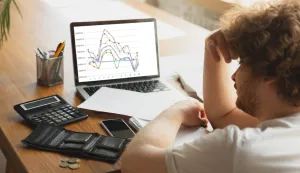 Portrait of caucasian unset and despair man watching financial and economical graphs during coronavirus quarantine, problems. Worldwide crisis.laptop, burza, dionice, novac, prevara, gubitak, ocaj, kriza, financije, besparice, graffreepik