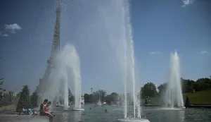 People jump in the Trocadero Fountain near the Eiffel Tower during a heatwave in Paris on June 22, 2026. The latest bout of exceptionally high temperatures to hit Europe has seen outdoor events cancelled, transport disrupted, schools shut and office workers told to work from home, as the authorities issued health alerts to protect the elderly and vulnerable. In France, the epicentre of the weather anomaly, 54 of the country's 96 mainland departments were on the highest heat alert, with temperatures forecast to climb up to 43C in the southwestern city of Bordeaux and 39C in the capital Paris, said national weather service Meteo-France. (Photo by JULIEN DE ROSA/AFP)