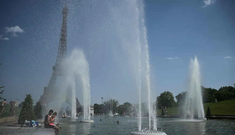 People jump in the Trocadero Fountain near the Eiffel Tower during a heatwave in Paris on June 22, 2026. The latest bout of exceptionally high temperatures to hit Europe has seen outdoor events cancelled, transport disrupted, schools shut and office workers told to work from home, as the authorities issued health alerts to protect the elderly and vulnerable. In France, the epicentre of the weather anomaly, 54 of the country's 96 mainland departments were on the highest heat alert, with temperatures forecast to climb up to 43C in the southwestern city of Bordeaux and 39C in the capital Paris, said national weather service Meteo-France. (Photo by JULIEN DE ROSA/AFP)
