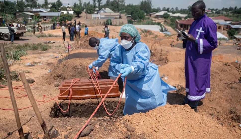 Teams from the International Federation of the Red Cross and Red Crescent Societies prepare for burial at Mbiyo cemetery the body of a fourth orphan who died from Ebola virus disease at an orphanage in Bunia, Ituri Province, June 19, 2026. A virus but no vaccine, a territory prey to armed groups and public distrust: Ebola resurfaced in mid-May at the borders of the DRC, Uganda and South Sudan. Since then, health authorities have been engaged in a race to catch up with the epidemic.On May 15, the Democratic Republic of Congo (DRC) declared the 17th Ebola outbreak, caused by the Bundibugyo strain, in the vast Central African country. The day before, tests carried out in a laboratory in the capital, Kinshasa, had confirmed the presence of the virus.The epicenter of the crisis is in Ituri, a troubled province in northeastern Congo marked by high population mobility linked to mining activity. Already 246 suspected cases, including 80 deaths, had been reported at that point. (Photo by Jospin Mwisha/AFP)