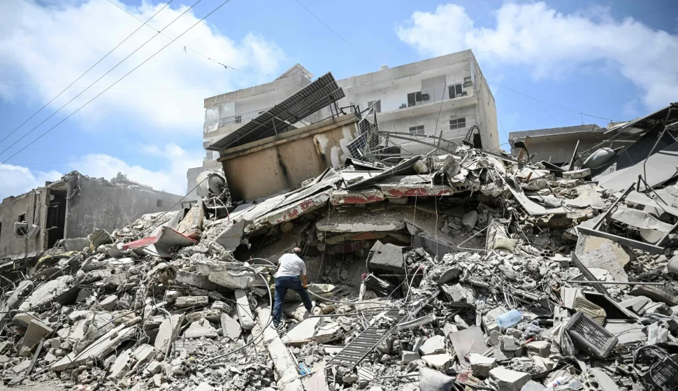 A man walks on the rubbles as he looks for items in a building hit in earlier Israeli military strikes on a neighbourhood in the southern Lebanese coastal city of Tyre on June 23, 2026. On June 22, 2026, mediators Pakistan and Qatar said that Tehran and Washington had agreed to set up a "de-confliction cell" to limit flare-ups in Lebanon following talks in Switzerland on ending the wider Middle East war, which Tehran has linked to halting the parallel conflict in Lebanon. (Photo by Joseph EID/AFP)/