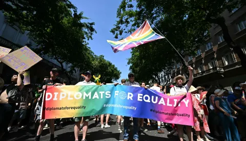 Participants hold a placard reading "Diplomats for equality" as people gather to the Budapest Pride Parade in Budapest, Hungary on June 27, 2026. (Photo by Attila KISBENEDEK/AFP)
