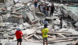 Venezuelan Civil Protection members and volunteers recover a body at the site of collapsed buildings following earthquakes in Caraballeda, La Guaira state, Venezuela, on June 26, 2026. The death toll from two powerful earthquakes that devastated Venezuela earlier this week rose to 920 on June 26, National Assembly President Jorge Rodriguez said. (Photo by Maryorin Mendez/AFP)