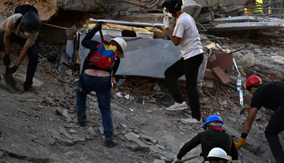 Volunteers work searching for possible victims at a collapsed building following twin earthquakes, in San Bernardino neighbourhood, in Caracas on June 27, 2026. The death toll in Venezuela's twin earthquake disaster reached 1,430 and millions more were feared to lack sanitation and other basic needs as the first US aid flights trickled into Caracas. (Photo by Juan BARRETO/AFP)