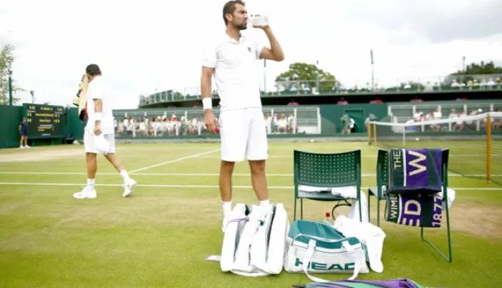 epa06079548 Marin Cilic (C) of Croatia in between games against Roberto Bautista Agut (L) of Spain during their fourth round match for the Wimbledon Championships at the All England Lawn Tennis Club, in London, Britain, 10 July 2017. EPA/NIC BOTHMA EDITORIAL USE ONLY/NO COMMERCIAL SALES------3x color - sport