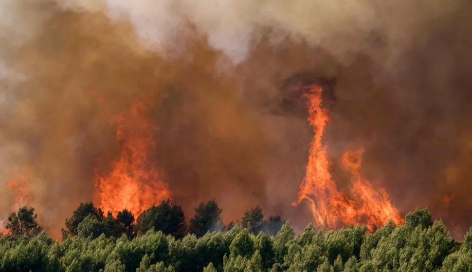This photograph shows a wildfire raging near houses in Pouzols-Minervois, southwestern of France, on July 2, 2026. Hundreds of firefighters are battling wildfires in the south that are being fueled by wind, drought, and heat. The largest fire is in the Aude department, but there are also fires north of Marseille, where Prime Minister is expected to chair a new interministerial crisis task force. (Photo by Idriss Bigou-Gilles/AFP)