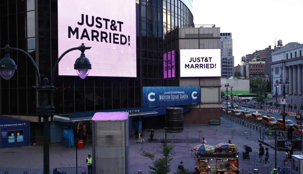 Giant screens showing the message "JUST&T MARRIED!" (T&T for Taylor and Travis) are seen outside Madison Square Garden, the reported venue for the wedding celebrations of pop singer Taylor Swift and pro-athlete Travis Kelce, in New York City on July 3, 2026. Swift and Kelce's official wedding plans are tightly under wraps, but New York is bracing to host the celebrity marriage of the year this week at Madison Square Garden. The wedding will reportedly take place Friday with a star-studded guest list of around 1,000, including models Gigi Hadid and Cara Delevingne, singer Selena Gomez, and actress Zoe Kravitz -- all known to be close Swift pals -- and Kelce's Kansas City Chiefs teammates. (Photo by CHARLY TRIBALLEAU/AFP)