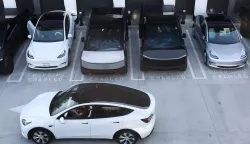(FILES) Tesla electric vehicles, including the Cybertruck, charge at stations during the opening of the Tesla Diner and Drive-In restaurant and Supercharger on Santa Monica Blvd in the Hollywood neighborhood Los Angeles, California on July 21, 2025. Tesla reported higher first-quarter profits Wednesday, pointing to recovering demand in North America as it pursues significant investments in autonomous transport and artificial intelligence. (Photo by Patrick T. Fallon/AFP)