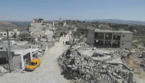 A man walks past destruction in the southern Lebanese village of Froun on June 30, 2026. Israeli Prime Minister Benjamin Netanyahu visited troops in southern Lebanon on June 30, vowing that his country's forces would stay in the area as long as Iran-backed Hezbollah remained a "threat". (Photo by Kawnat HAJU/AFP)/