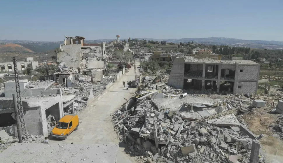 A man walks past destruction in the southern Lebanese village of Froun on June 30, 2026. Israeli Prime Minister Benjamin Netanyahu visited troops in southern Lebanon on June 30, vowing that his country's forces would stay in the area as long as Iran-backed Hezbollah remained a "threat". (Photo by Kawnat HAJU/AFP)/