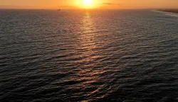 HUNTINGTON BEACH, CALIFORNIA - JULY 01: In an aerial view, the sun sets over the Pacific Ocean on July 01, 2026 in Huntington Beach, California. Global ocean sea surface temperatures broke records in June, according to the EU?s Copernicus Climate Change Service and the Copernicus Marine Service. Earth?s average ocean temperatures hit about 21 degrees Celsius (around 69.5 degrees Fahrenheit) on June 21, marking an ?unprecedented? new record for June amid the onset of ?El Ni?o?. Mario Tama/Getty Images/AFP (Photo by MARIO TAMA/GETTY IMAGES NORTH AMERICA/Getty Images via AFP)