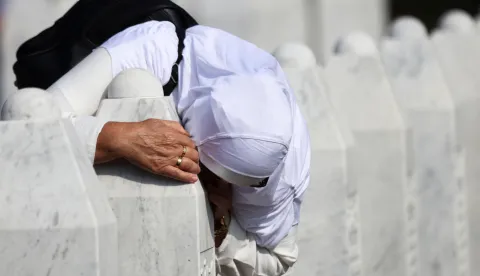 A Bosnian Muslim woman reacts amid grave stones of victims killed during the Srebrenica genocide, at the Srebrenica Genocide Memorial in Potocari, Bosnia and Herzegovina, July 11, 2025. REUTERS/Amel Emric Photo: AMEL EMRIC/REUTERS