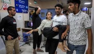 EDITORS NOTE: Graphic content/A girl who was injured following a reported Israeli strike on a tent according to medics, is carried by a man to the trauma ward for treatment at Nasser Medical Complex in Khan Yunis in the southern Gaza Strip on July 8, 2026. Violence continues in Gaza despite a ceasefire between Hamas and Israel in place since October 2025. At least 1,072 Palestinians have been killed in the territory since the truce took effect, according to the territory's health ministry, which operates under Hamas authority and whose figures are considered reliable by the United Nations. (Photo by Bashar Taleb/AFP)