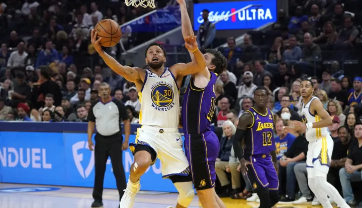 epa10251863 Golden State Warriors guard Stephen Curry (L) goes to the basket for two points as Los Angeles Lakers guard Austin Reaves (R) defends during the first half of the NBA game at Chase Center in San Francisco, California, USA, 18 October 2022. EPA/JOHN G. MABANGLO SHUTTERSTOCK OUT