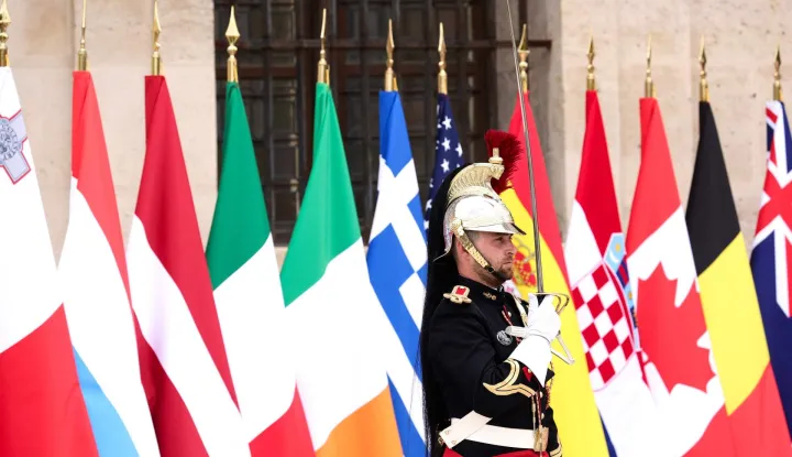A French Republican Guard stands next to the flags during a summit of the Coalition of the Willing to support Ukraine at the Hotel des Invalides in Paris on July 13, 2026. The summit meeting of the Coalition of the Willing -- launched by France and the United Kingdom to provide military support to Ukraine after Russia's full-scale invasion -- will push for a ceasefire and renewed peace talks, the French presidency said. (Photo by Teresa Suarez/POOL/AFP)