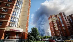 This photograph shows smoke rising from a fire at the Russian e-commerce firm Wildberries' logistics complexes in the town of Elektrostal outside Moscow on July 18, 2026. A Ukrainian drone attack on two logistics centres in Russia killed eight people and injured 24, officials said on July 18, 2026, when the Moscow region reported a new wave of drone strikes. Russian e-commerce firm Wildberries said its logistics complexes in Kotovsk and Elektrostal, in the Tambov and Moscow regions respectively, came under attack. One person was killed and 37 were injured at the Elektrostal warehouse, according to the region's governor, Andrei Vorobyov. (Photo by TATYANA MAKEYEVA/AFP)