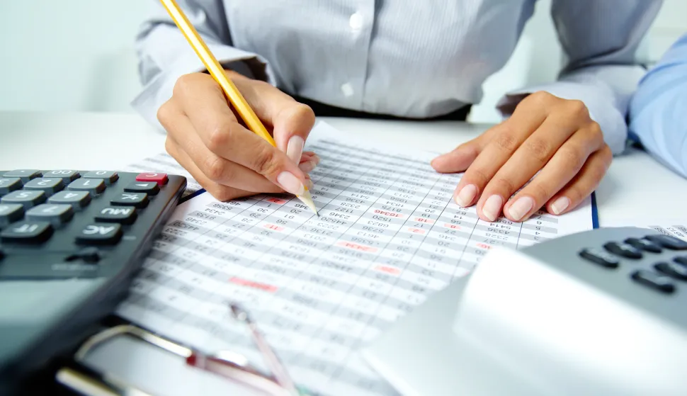 Photo of human hands holding pencil and ticking data in documents računovođa računovodstvo računi novac izvje&scaron;će bilanca 