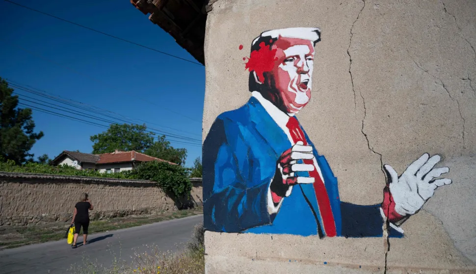 A local resident walks by a mural depicting US President Donald Trump in the village of Staro Zhelezare, on July 23, 2026. Since 2015, students from Poland have been gathering every summer in Bulgarian village of Staro Zhelezare to paint graffiti on the walls of the houses belonging to the village?s mere 400 residents. The themes of the paintings are often related to current events in world politics. (Photo by Nikolay DOYCHINOV/AFP)/RESTRICTED TO EDITORIAL USE - MANDATORY MENTION OF THE ARTIST UPON PUBLICATION - TO ILLUSTRATE THE EVENT AS SPECIFIED IN THE CAPTION