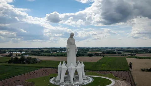 This aerial photo taken on July 22, 2026, shows a statue of the Virgin Mary during finishing works at the construction site in Konotopie village, next to Torun, central Poland. In a nondescript village in northern-central Poland, a statue of the Virgin Mary, towers above what residents hope is the traditionally Catholic country's newest pilgrimage destination. At 55 meters high, the concrete and steel beam figure in Konotopie is the tallest Marian statue in Europe, and second in the world. (Photo by Wojtek RADWANSKI/AFP)