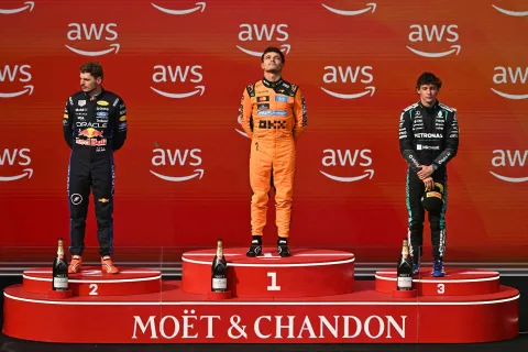 TOPSHOT - (LtoR) Second placed Red Bull Racing's Dutch driver Max Verstappen, winner McLaren's British driver Lando Norris and third placed Mercedes' Italian driver Kimi Antonelli celebrate on the podium after the Formula One Hungarian Grand Prix at the Hungaroring racetrack in Mogyorod near Budapest, Hungary, on July 26, 2026. (Photo by Attila KISBENEDEK/AFP)