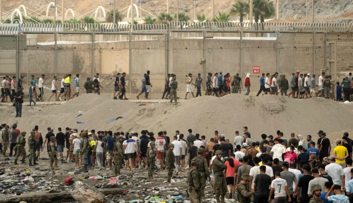 Spanish soldiers control as migrants cross back to Morocco after they crossed the border to enter Spain's north Africa's Ceuta enclave on July 31, 2026. Thousands of migrants crossed overnight from Morocco into Ceuta enclave, a police source said, as Spanish Prime Minister was set to arrive to manage the latest migrant crisis on the border. In recent days, a total of around 40,000 migrants have crossed into the territory, population 80,000, the source added. (Photo by JORGE GUERRERO/AFP)