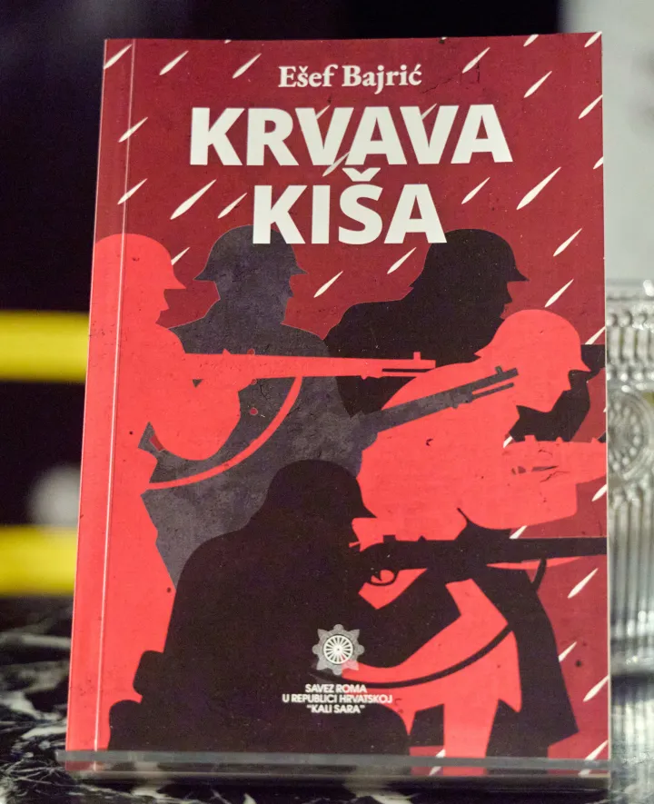 Zagreb, 01.08.2026. - Kulturnom večeri u Zagrebu obilježen Međunarodni dan sjećanja na romske žrtve genocida. Savez Roma u Republici Hrvatskoj "Kali Sara" organizirao je u Zagrebu kulturnu večer u povodu obilježavanja Međunarodnog dana sjećanja na romske žrtve genocida u Drugom svjetskom ratu. U sklopu programa predstavljena je knjiga "Krvava ki&scaron;a" E&scaron;efa Bajrića.Na fotografiji ilustracija knjiga Krvava ki&scaron;a.foto HINA/ Edvard &Scaron;U&Scaron;AK /es