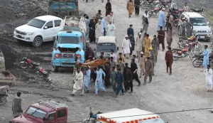Coal miners and relatives carry the body of a miner after a coal mine collapsed in the Surange area, about 50 kilometres east of Quetta, on July 30, 2026. (Photo by Banaras KHAN/AFP)