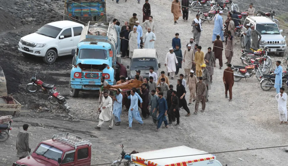Coal miners and relatives carry the body of a miner after a coal mine collapsed in the Surange area, about 50 kilometres east of Quetta, on July 30, 2026. (Photo by Banaras KHAN/AFP)
