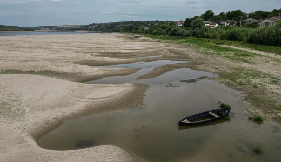 An aerial view shows a dried-out river bed of Danube in Rasova village August 3, 2026. Romanian army forces detonated an explosive load into the rock bed of Danube in Izvoarele village, kilometers away from Rasova, to help diverting a higher volume of water toward the cooling systems of the Cernavoda Nuclear Power Plant. Local authorities and plant engineers authorized the blasting operations to counteract critically low water levels caused by a prolonged summer heatwave, ensuring the continuous and safe operation of the facility's reactors. (Photo by Daniel MIHAILESCU/AFP)