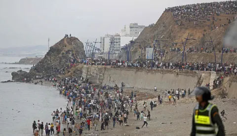 People gather along the fence at the site of clashes near Fnideq, on the Morocco-Spain border, on July 31, 2026. Thousands of migrants crossed overnight from Morocco into Spain's north Africa's Ceuta enclave, a police source said on July 31, as Prime Minister Pedro Sanchez was set to arrive to manage the latest migrant crisis on the border. (Photo by Abdel Majid BZIOUAT/AFP)