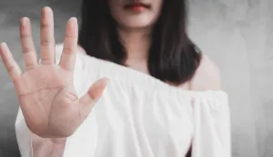 Closeup portrait young annoyed angry woman with bad attitude giving talk to hand gesture with palm outward isolated grey wall background. Negative human emotion face expression feeling body language.seksualno uzemiravanje zlostavljanje obiteljsko nasilje ilustracija freepik