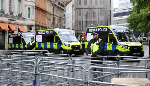 Police officers stand guard before supporters of British far-right activist Tommy Robinson, real name Stephen Yaxley-Lennon, take part in a march organised by Unite The Kingdom, in central London on May 16, 2026. (Photo by Toby Shepheard/AFP)