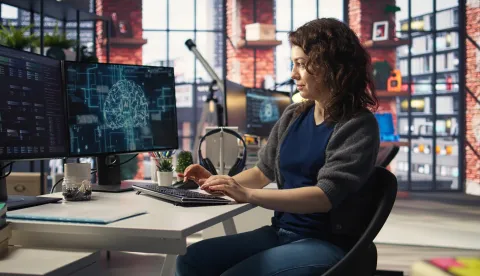 Teleworking developer using computer for artificial intelligence computing through self learning algorithms. Agency IT engineer works with AI deep neural networks on desktop PC. Camera A.umjetna inteligencija, AI, računalo, tehnologija