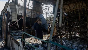 A woman looks at burnt and broken ceramic items at a damaged street market following Russian strikes in Petrivka neighbourhood in Kyiv on August 9, 2026, amid the Russian invasion of Ukraine. (Photo by Tetiana DZHAFAROVA/AFP)