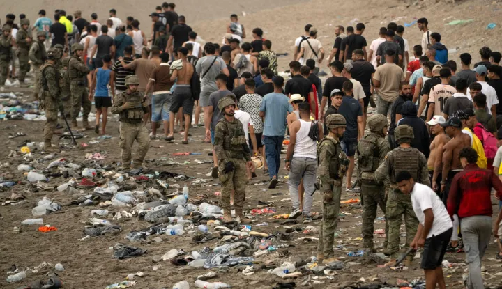 Spanish soldiers control as migrants cross back to Morocco after they crossed the border to enter Spain's north Africa's Ceuta enclave on July 31, 2026. Thousands of migrants crossed overnight from Morocco into Ceuta enclave, a police source said, as Spanish Prime Minister was set to arrive to manage the latest migrant crisis on the border. In recent days, a total of around 40,000 migrants have crossed into the territory, population 80,000, the source added. (Photo by JORGE GUERRERO/AFP)