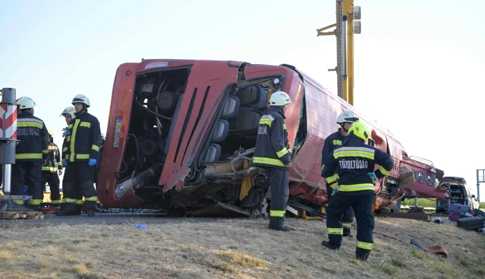 Rescue workers and other officials work at the wreckage of an overturned Polish tourist bus on the M3 motorway near Mezokeresztes, about 150 km east of the Hungarian capital Budapest, on August 16, 2026. A Polish bus overturned on a Hungarian highway early Sunday, August 16, 2026, killing 12 people and leaving at least 10 with serious injuries, Hungary's Prime Minister Peter Magyar and officials said. The coach, heading from Serbia to Poland, crashed at 1:00 am (2300 GMT Saturday) on the M3 highway near Mezokeresztes, east of Budapest, according to a police statement. (Photo by Zoltan MATHE/MTI/AFP)/Hungary OUT