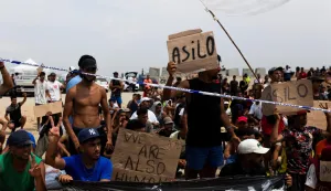 Migrants hold signs reading "Asilo," Spanish for "asylum," as they gather in Ceuta, Spain, August 16, 2026. REUTERS/Maria Alejandra Cardona Photo: MARIA ALEJANDRA CARDONA/REUTERS