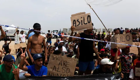 Migrants hold signs reading "Asilo," Spanish for "asylum," as they gather in Ceuta, Spain, August 16, 2026. REUTERS/Maria Alejandra Cardona Photo: MARIA ALEJANDRA CARDONA/REUTERS