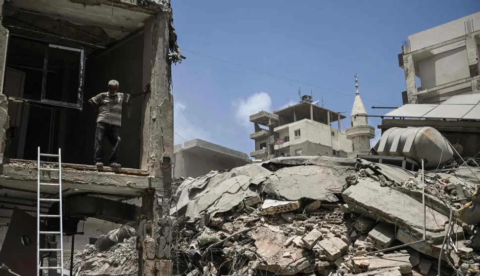 A construction worker rests as he removes debris from a damaged building next to a flattened building at the site of an earlier Israeli military strike on a neighbourhood in the southern Lebanese coastal city of Tyre on June 23, 2026. On June 22, 2026, mediators Pakistan and Qatar said that Tehran and Washington had agreed to set up a "de-confliction cell" to limit flare-ups in Lebanon following talks in Switzerland on ending the wider Middle East war, which Tehran has linked to halting the parallel conflict in Lebanon. (Photo by Joseph EID/AFP)/