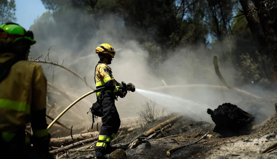 CORRECTION/Firefighters douse the ground to prevent reignition after a wildfire was brought under control near La Adrada, 95 kilometres west of Madrid, on July 28, 2026. Spanish Prime Minister Pedro Sanchez said today that the country is starting to see the light at the "end of the tunnel in the fight against these wildfires," although he warned of "particularly complex hours" ahead as a new heatwave is set to hit the country starting tomorrow. The provinces of Avila, Madrid, Toledo, and Castellon continue to battle wildfires that have already burned over 77,000 hectares and forced the preventive evacuation of 63,000 people, according to figures from the Ministry of the Interior. (Photo by Oscar DEL POZO/AFP)/?The erroneous caption appearing in the metadata of this photo by Oscar DEL POZO has been modified in AFP systems in the following manner: [Firefighters douse the ground to prevent reignition after a wildfire was brought under control near La Adrada, 95 kilometres west of Madrid, on July 28, 2026.] instead of [This picture shows a burnt-out house in the residential area of Santa Barbara in La Vilavella, 50 kilometres north of Valencia, on July 28, 2026.]. Please immediately remove the erroneous mention[s] from all your online services and delete it (them) from your servers. If you have been authorized by AFP to distribute it (them) to third parties, please ensure that the same actions are carried out by them. Failure to promptly comply with these instructions will entail liability on your part for any continued or post notification usage. Therefore we thank you very much for all your attention and prompt action. We are sorry for the inconvenience this notification may cause and remain at your disposal for any further information you may require.?