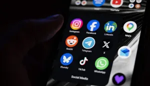 (FILES) This photograph shows a set up smart-phone screen displaying the logo of main social media platforms including Instagram, Facebook, LinkedIn, Reddit, Telegram, X, Bluesky, Tiktok and Whatsapp in Saint-Mande, east of Paris, on April 29, 2026. On August 14, 2026, the French Constitutional Council struck down the ban on social media for under-15s, ruling that this measure constitutes "a disproportionate infringement" of their freedom of expression. (Photo by Martin LELIEVRE/AFP)