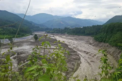 A torrent of muddy water surges through Trishuli river after flash floods in Nepal's Nuwakot district on August 26, 2026. Massive flooding killed eight people in Nepal on August 26, as Chinese state media reported "major casualties" from a mudslide at a Tibet trade hub on China's side of the nations' shared border. (Photo by Anup OJHA/AFP)