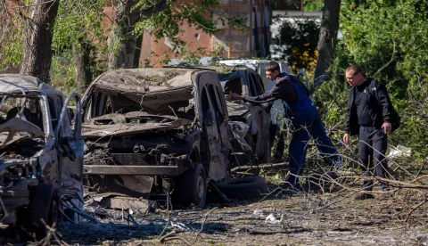 Two men inspect destroyed cars at the site of an air attack in Dnipro on June 2, 2026, amid the Russian invasion of Ukraine. Russia pummelled Ukraine with hundreds of drones and dozens of missiles early on June 2, 2026, killing at least 11 people, after threatening a large-scale attack and warning foreign citizens to leave Kyiv. (Photo by Mykola SYNELNYKOV/AFP)