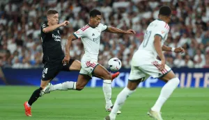 Real Madrid's English midfielder #05 Jude Bellingham (C) controls the ball challenged by Real Sociedad's Croatian midfielder #24 Luka Susic during the Spanish league football match between Real Madrid CF and Real Sociedad at Santiago Bernabeu Stadium in Madrid on August 26, 2026. (Photo by Thomas COEX/AFP)