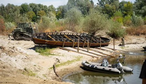 Osijek, 19. 8. 2026., Izvlačenje replike rimskog broda Danuvina Alacris na obali Drave Danuvina Alacris; rimski antički brod; replika antičkog broda; muzejski eksponat; riječno plovilo; MORH; vojska