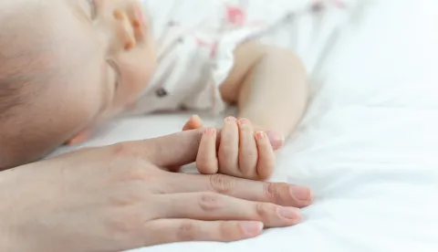 The newborn baby sleeps and grabs the mother's fingermajka beba roditelji novorođenče ruka dijete rođenje ilustracija freepik