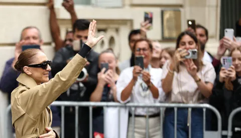 Canadian singer Celine Dion acknowledges fans as she arrives at Hotel Le Royal Monceau in Paris on August 28, 2026, ahead of he series of concerts in the French capital. Celine Dion, 58, announced in late March, in a video and a message projected onto the Eiffel Tower, her return to the stage, in Paris, after six years away from the public, between the pandemic and persistent health problems. She has suffered since 2022 from stiff person syndrome, a rare and incurable neurological condition. (Photo by SIMON WOHLFAHRT/AFP)