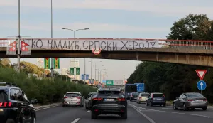 A banner reading "Ratko Mladic, Serbian Hero" is displayed on a footbridge over a motorway as a convoy carrying the body of Bosnian Serb war criminal Ratko Mladic passes through Belgrade, Serbia, on September 3, 2026. Mladic's body arrived in Serbia earlier in the day and was driven from the airport under police escort after being received with military honours. Mladic died the previous week while serving a life sentence for genocide, war crimes and crimes against humanity committed during the 1992-1995 Bosnian war. (Photo by Pedja MILOSAVLJEVIC/AFP)